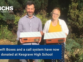 Two people standing looking at the camera holding Swift boxes