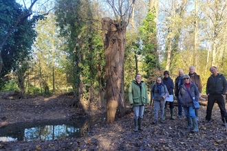 Staff from Suffolk Wildlife Trust and members of the Bury Water Meadows Group stand by a newly created backwater