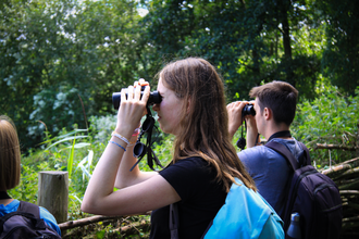 Two students looking through binoculars 