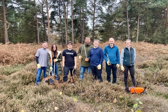 A group of people standing in a wooded landscape 