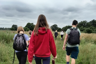 young people walking across a field at Lackford Lakes