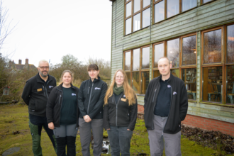 Five people from the Lackford Lakes team standing in front of the Visitor Centre