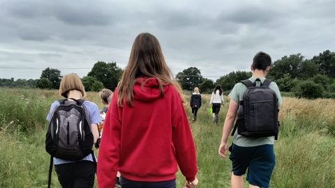 young people walking across a field at Lackford Lakes