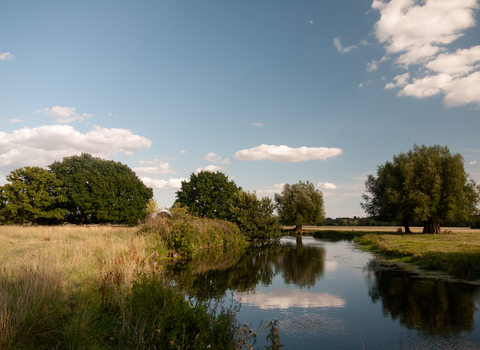 A view of the River Deben winding through the sunny countryside of the Stour Valley in Suffolk